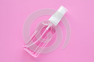 Cosmetic bottle with hand sanitizer, antiseptic spray for disinfection. Remover liquid in container on a pink background. Cleanser