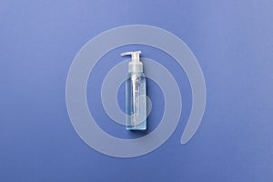 Cosmetic bottle with liquid lying on blue background
