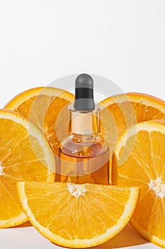 Cosmetic bottle product serum vitamin C with orange slices on white background, mockup, copy space