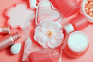 Cosmetic bottles and jars on a pink monochrome background. Asian cosmetics for skin care