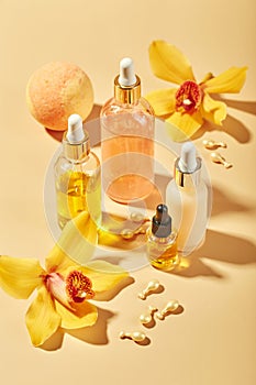 Cosmetic care products in glass bottles with orchid flowers - serums, cream, gel, oils. Concept for face and body care