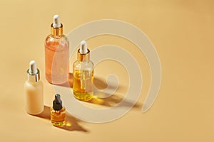 Cosmetic care products in glass bottles with orchid flowers - serums, cream, gel, oils. Concept for face and body care