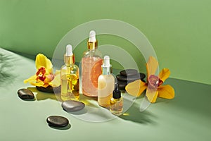 Cosmetic care products in glass bottles with orchid flowers - serums, cream, gel, oils. Concept for face and body care