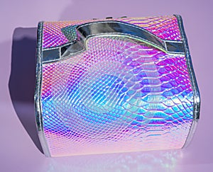 Cosmetic case on abstract background with holographic bright rainbow multicolor. Metallized macro close up. Imitation of