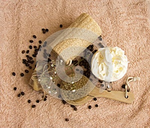 Cosmetic concept with towel, brush soap scrub, coffee beans, flower