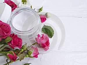 Cosmetic cream beauty with roses a white wooden background