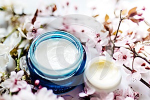 Cosmetic cream and concealer eyes creams with pink cherry flowers.Skincare lotion products