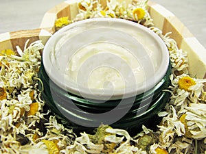 Cosmetic cream for face care and daisy flowers