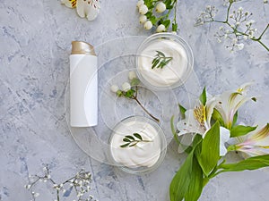 Cosmetic cream, flower  on  concrete background
