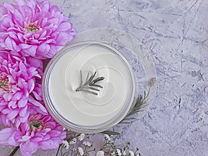 Cosmetic cream, flower on on a concrete background