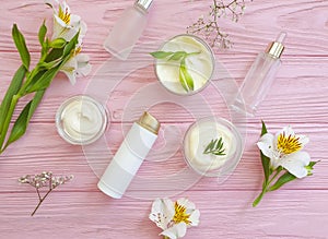 Cosmetic cream, flower on on a wooden background