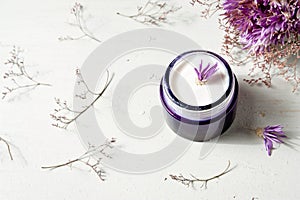 Cosmetic cream and lavender flowers on white wood table background