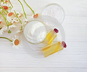 Cosmetic cream, mask oil chamomile flower freshnessorganic on a white wooden background