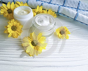 Cosmetic cream organic a jar yellow chrysanthemum flower white wooden, daisy, towel