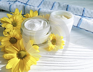 Cosmetic cream organic morning skincare a jar yellow chrysanthemum flower white wooden, daisy, towel