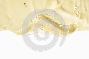 Cosmetic cream transparent liquid gel. Yellow gel smudge isolated on white background. Skincare lotion face serum swatch