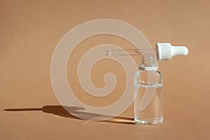 Cosmetic dropper bottle for serum, micellar toner and emulsion on brown background
