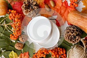 Cosmetic face or body cream on autumn nature wood background with red and yellow leaves