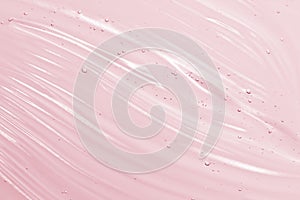 Cosmetic gel background. Face serum, clear beauty cream texture. Pink colored transparent skincare product close-up photo