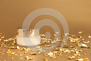 Cosmetic glass jar with white moisturizer. Luxurious anti-aging day cream with isoflavones and active microparticles of gold and