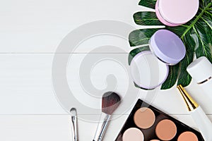 Cosmetic makeup and skin care product and leaves on white wood table, beauty with treatment cream and moisturizer