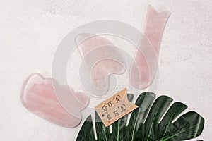 Cosmetic Massage Pink Jade Gua Sha Scrapers for Facial and Body Skin Care Spa and Beauty Concept Top View Horizontal Gray