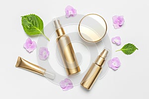 Cosmetic mock up gold bottles. Cosmetics, pink hydrangea flowers on light background. Cosmetics springtime summer Concept. Flat