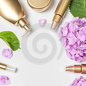Cosmetic mock up gold bottles. Cosmetics, pink hydrangea flowers on light background. Cosmetics springtime summer Concept. Flat