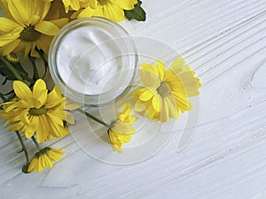 Cosmetic moisturizer cream wellness marguerite yellow chrysanthemum product chamomile white wooden