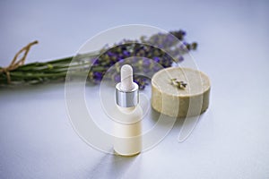 Cosmetic natural lavender soap bar and serum or essential oil on light grey background. Aromatherapy, spa concept