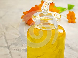 Cosmetic oil calendula flower on a gray concrete background