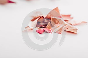 Cosmetic pink pencil shavings on white background