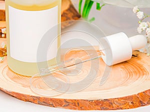 Cosmetic pipette with drops of facial serum collagen, citrus, vitamin C or yellow cosmetic oil close up