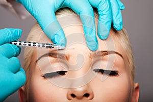 Cosmetic plastic surgeon injecting aesthetics face
