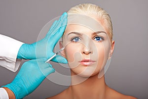 Cosmetic plastic surgeon injecting aesthetics face