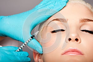 Cosmetic plastic surgeon injecting aesthetics face