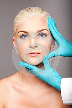 Cosmetic plastic surgeon touching aesthetics face