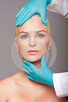 Cosmetic plastic surgeon touching aesthetics face