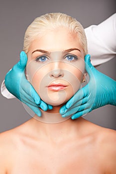 Cosmetic plastic surgeon touching aesthetics face