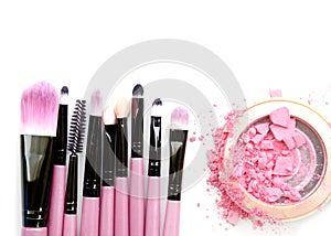 Cosmetic powder brush circle box and crushed blush palette on white.