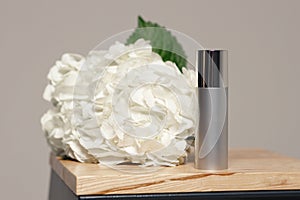 Cosmetic preparations on the table on the background of white flowers. The concept of cosmetology