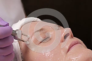 Cosmetic procedure for the rejuvenation of the skin with the use of electrodes of a microcurrent apparatus. Close-up of a female