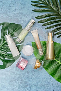 Cosmetic product and tropical leaves on concert background