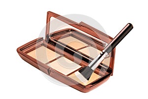 Cosmetic products isolated. Close-up of a elegant cosmetic multi-color box with mirror, eye shadows powder and a eye shadow brush