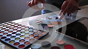 Cosmetic products with sequin stars arranged on a background, makeup artist arranges cosmetics