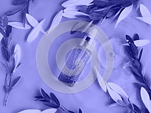 Cosmetic serum oil purple bottle on monochrome background in water