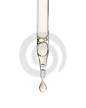 Cosmetic serum pipette with a yellow drop oil or aha asids close up on white isolated background