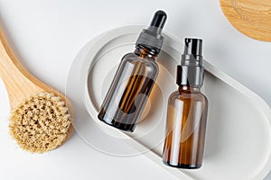 Cosmetic set for face skin exfoliation. Natuaral oil and peeling in dark glass bottles next to massaging brash with natural