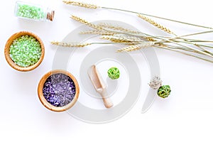 Cosmetic set with wheat herbs and sea salt in bottle on white table background flat lay