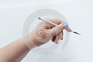 Cosmetic small brush for makeup in a female hand